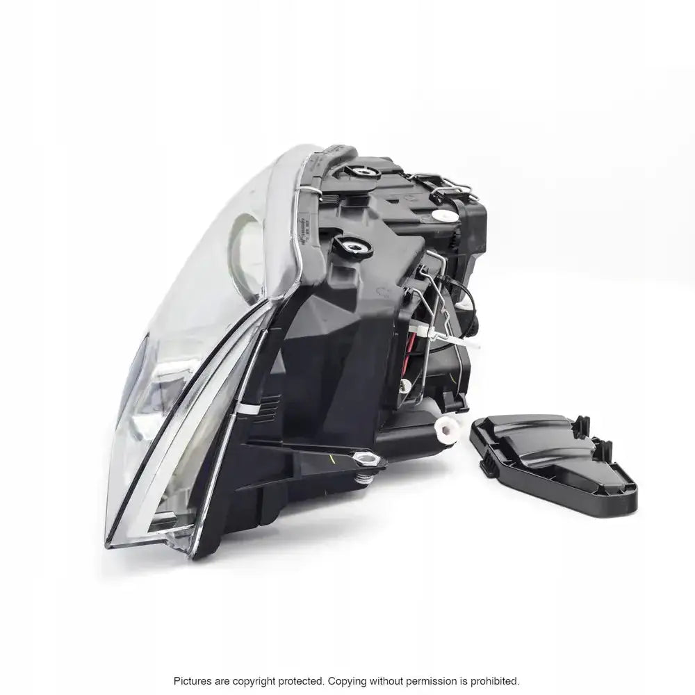 Headlights Skoda Superb frontlykt fra siden med synlig bakside, ledningsnett og løst lokk ved siden av.