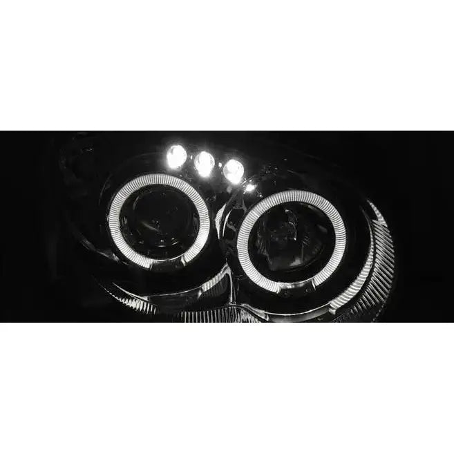 Headlights Subaru Impreza II GD 03-05 Angel Eyes Chrome med runde LED-lysringer vist opplyst i mørket.