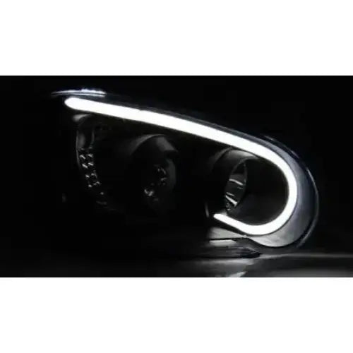 Hovedlys Subaru Impreza II GD 03-05 med svart hus og LED-lysbånd, sett fra skrå vinkel i mørkt miljø.