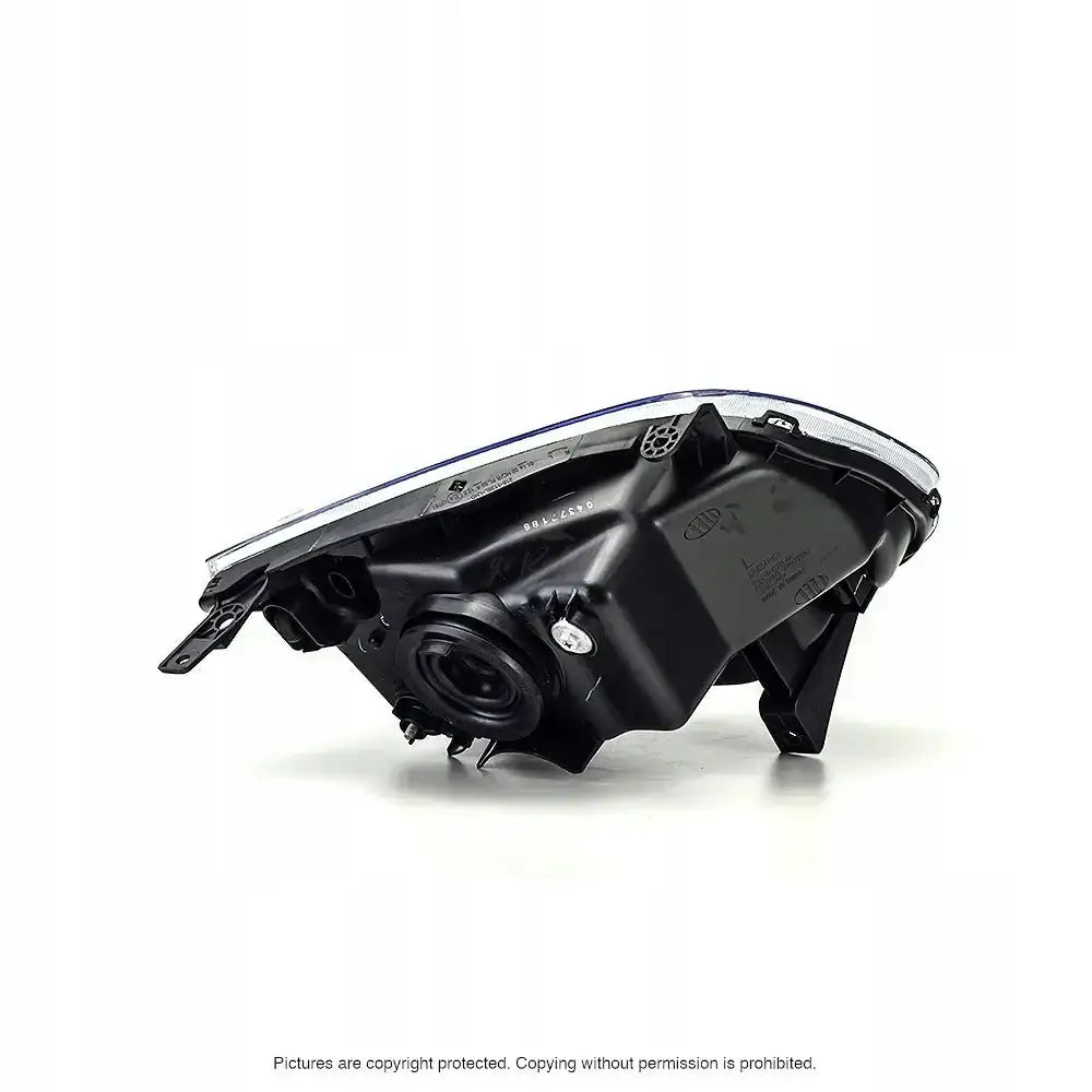 Headlamp Suzuki Ignis II 03-07 bakside med synlige monteringsfester og tekniske detaljer i svart og sølv plast.