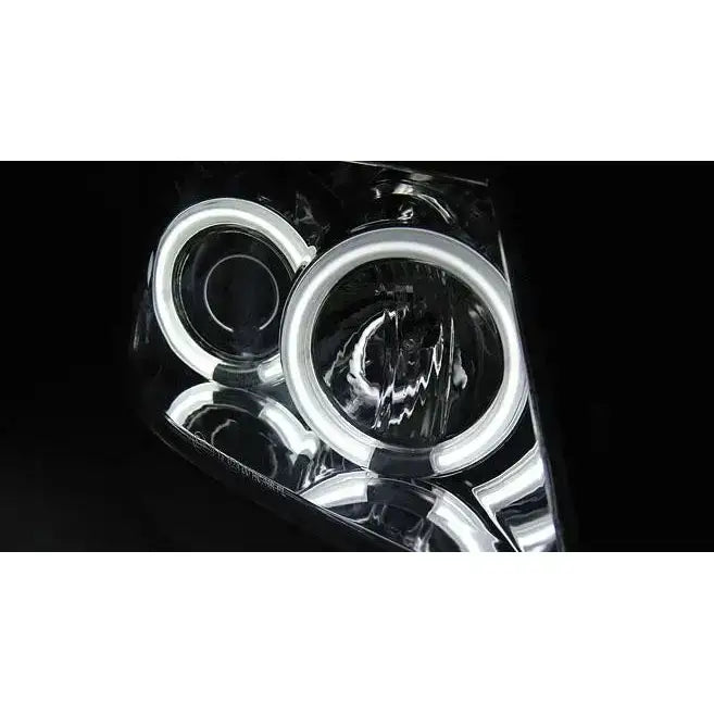 Hovedlys Suzuki Swift 05.05-10 med sirkulære LED-lysringer og kromdetaljer, sett fra skrå vinkel.