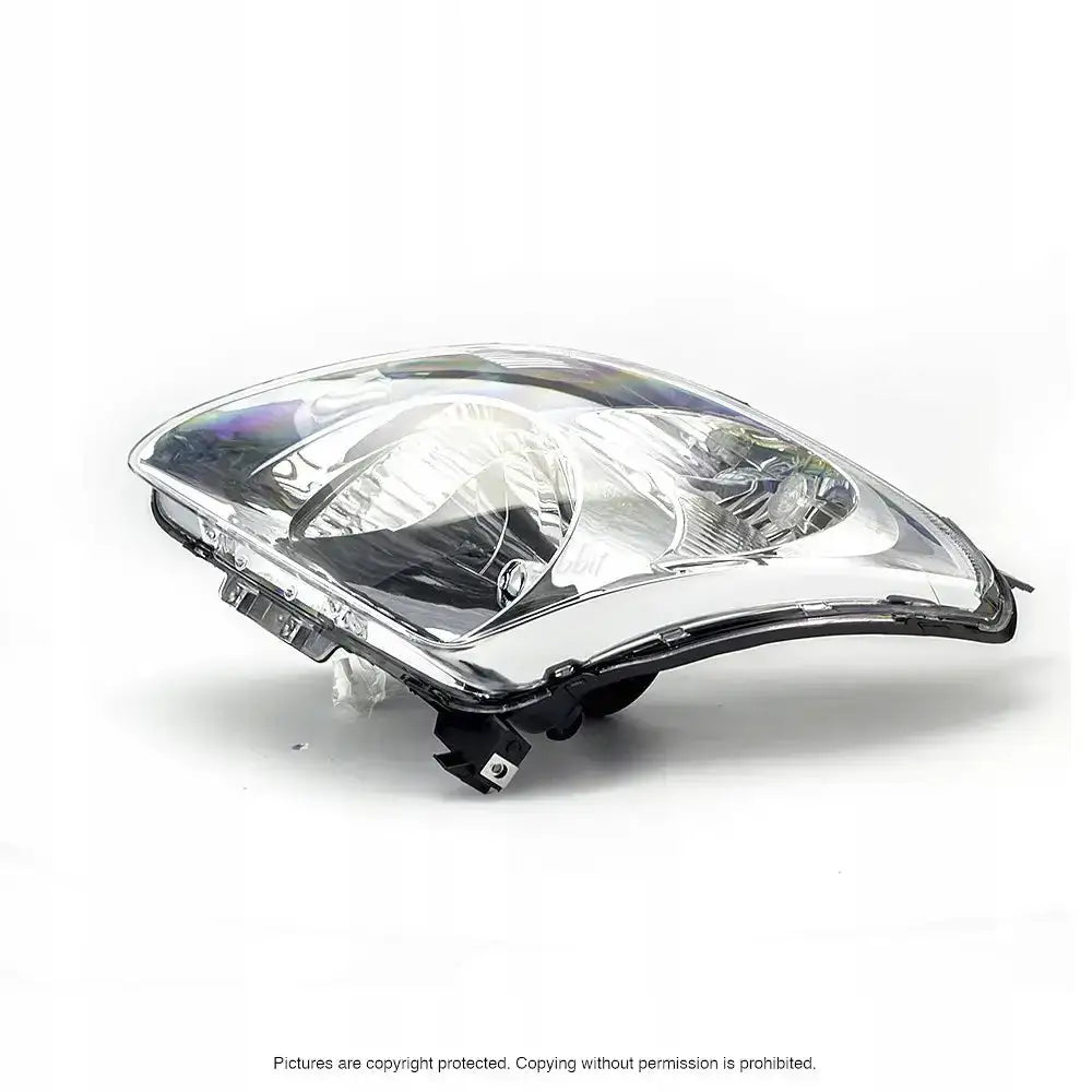 Frontlykter Suzuki Swift 05-07 H4 med klart glass og kromdetaljer sett fra skrå vinkel.