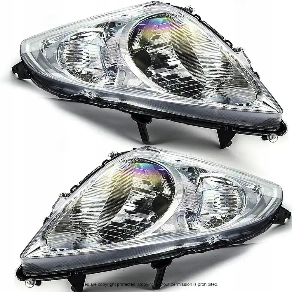 Frontlykter Suzuki Swift 10-13 med klart glass og sølvreflektorer, vist skrått forfra på hvit bakgrunn.