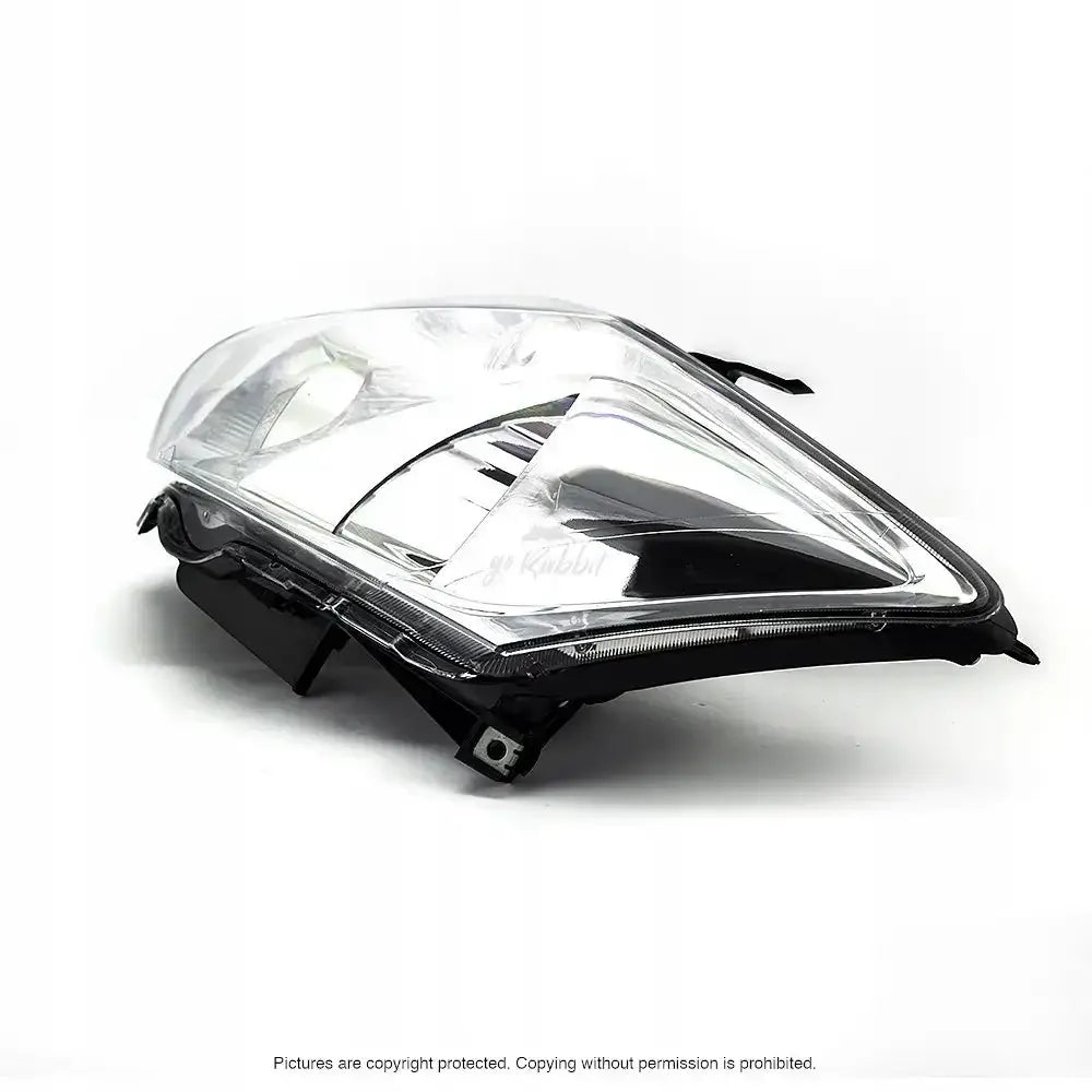 Hovedlys Toyota Auris I 07-10 med klart plastglass og sort ramme sett fra skrått sideperspektiv.