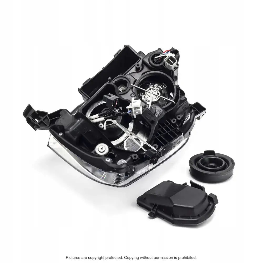 Hovedlys Toyota Avensis T25 03-06 halogen med sorte deksler og synlige ledninger sett skrått ovenfra.