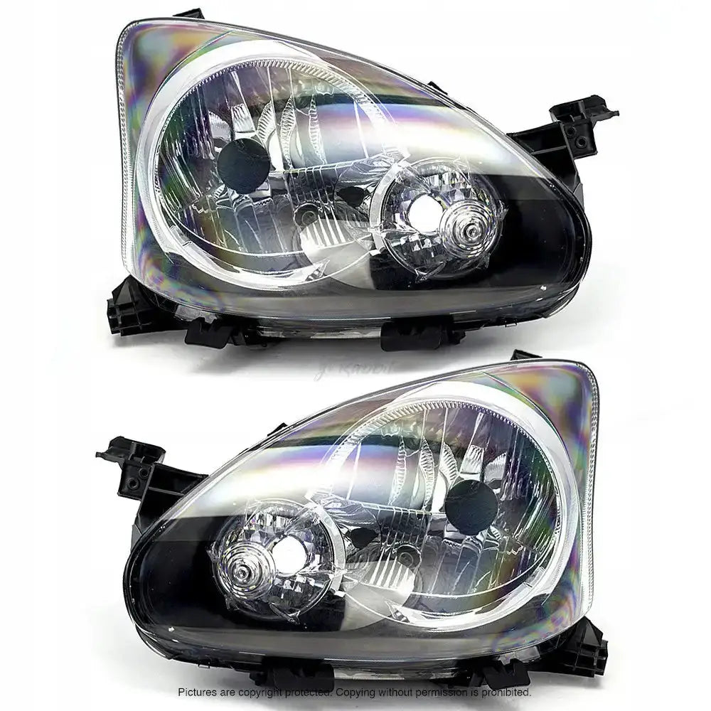 Frontlykter Toyota Aygo 08-12 i klar plast med sort innramming, sett fra skrå frontvinkel.