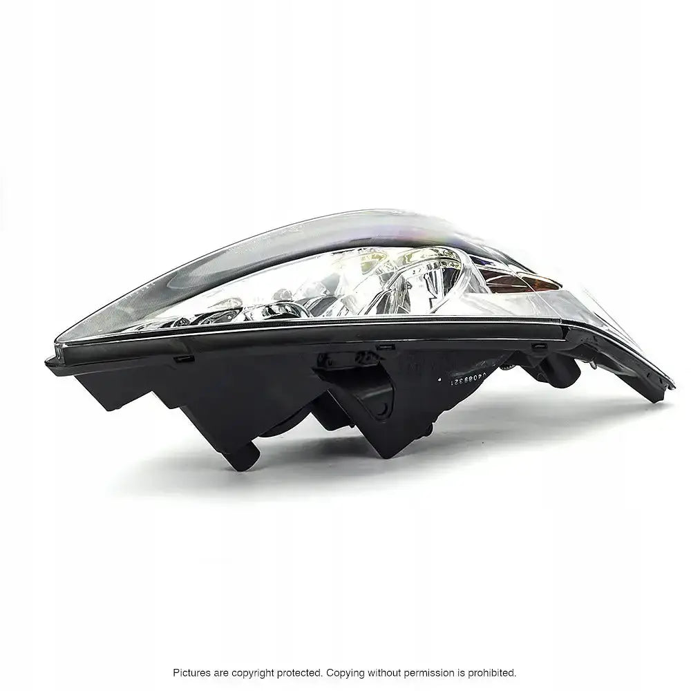 Frontlykter Toyota Camry 01-06 med klart glass og svart bakside sett fra lavt sideperspektiv.