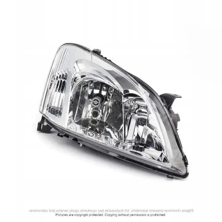 Hovedlykter Toyota Corolla E12 02-04 med klar plast og reflekterende detaljer sett fra skrå vinkel.