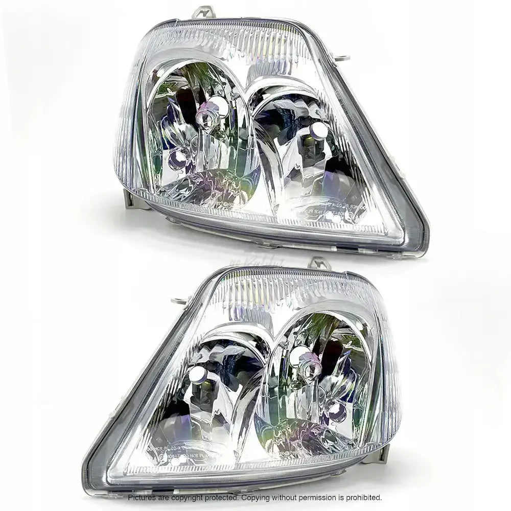 Frontlykter Toyota Corolla E12 04-07 med klar plast og krom, sett skrått forfra mot hvit bakgrunn.