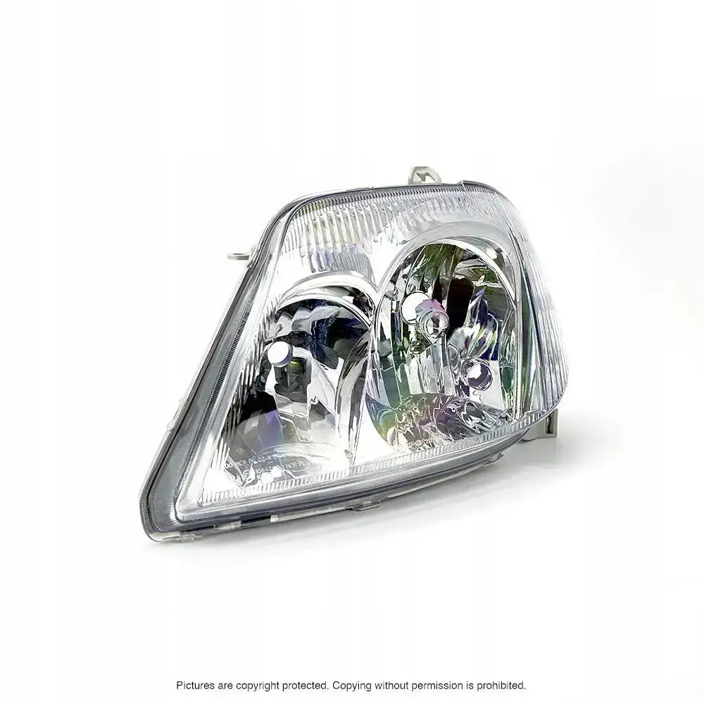 Hovedlykter Toyota Corolla E12 04-07 med klart glass, sølvdetaljer og doble lyssoner, skrått forfra.