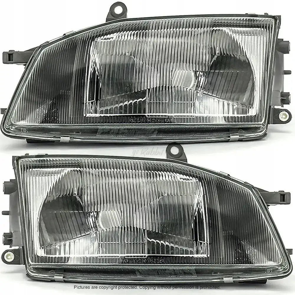 Frontlykter Toyota Hiace 95-06 i klart glass med svart plast og rillede overflater, sett forfra.