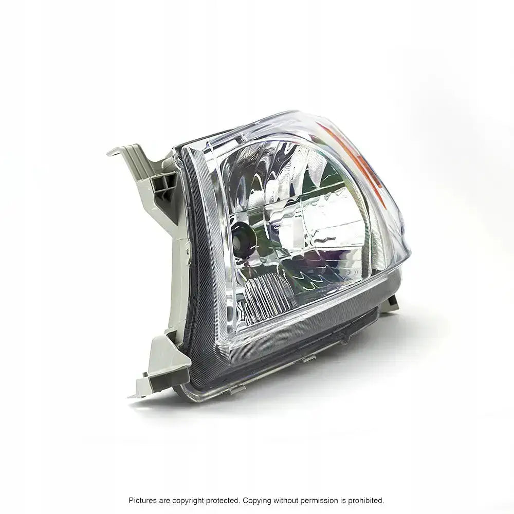 Headlights Toyota Hilux 04-08 H4 i klart plast med sølvreflekser, skrå sidevisning, synlige grå innfestninger.