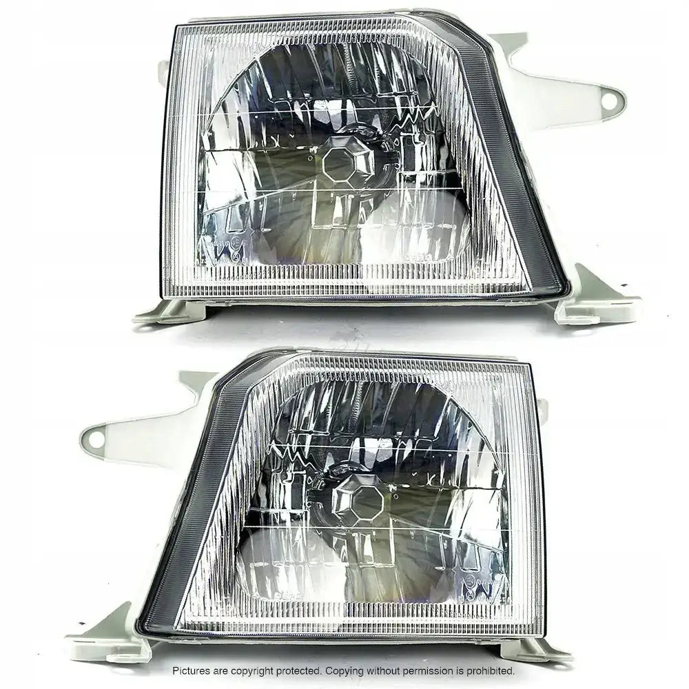 Frontlykter Toyota Land Cruiser J90 96-02 i klart glass, sett forfra med synlige metallfester.