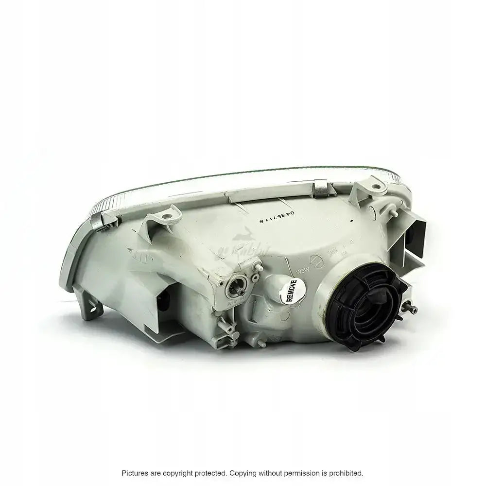 Headlights bakside av Toyota Rav4 1997 billykt med sort deksel og hvit merkelapp i plast.