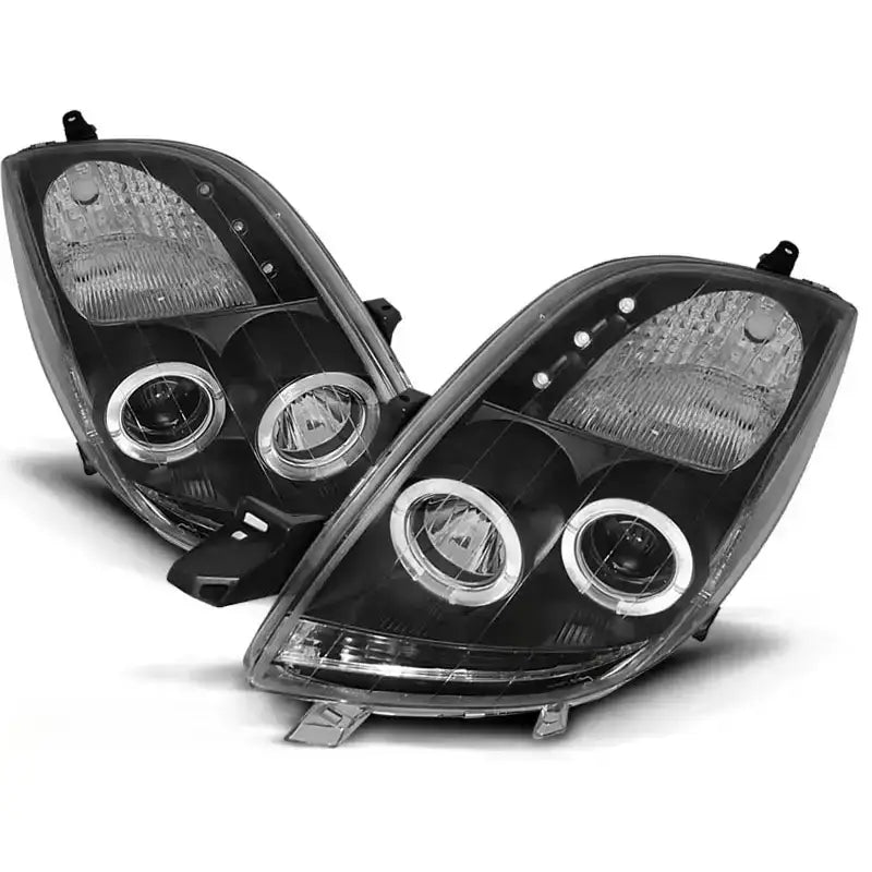 Hovedlykter Toyota YARIS 06-09 Angel Eyes Black i sort plast med klare linser og kromdetaljer.