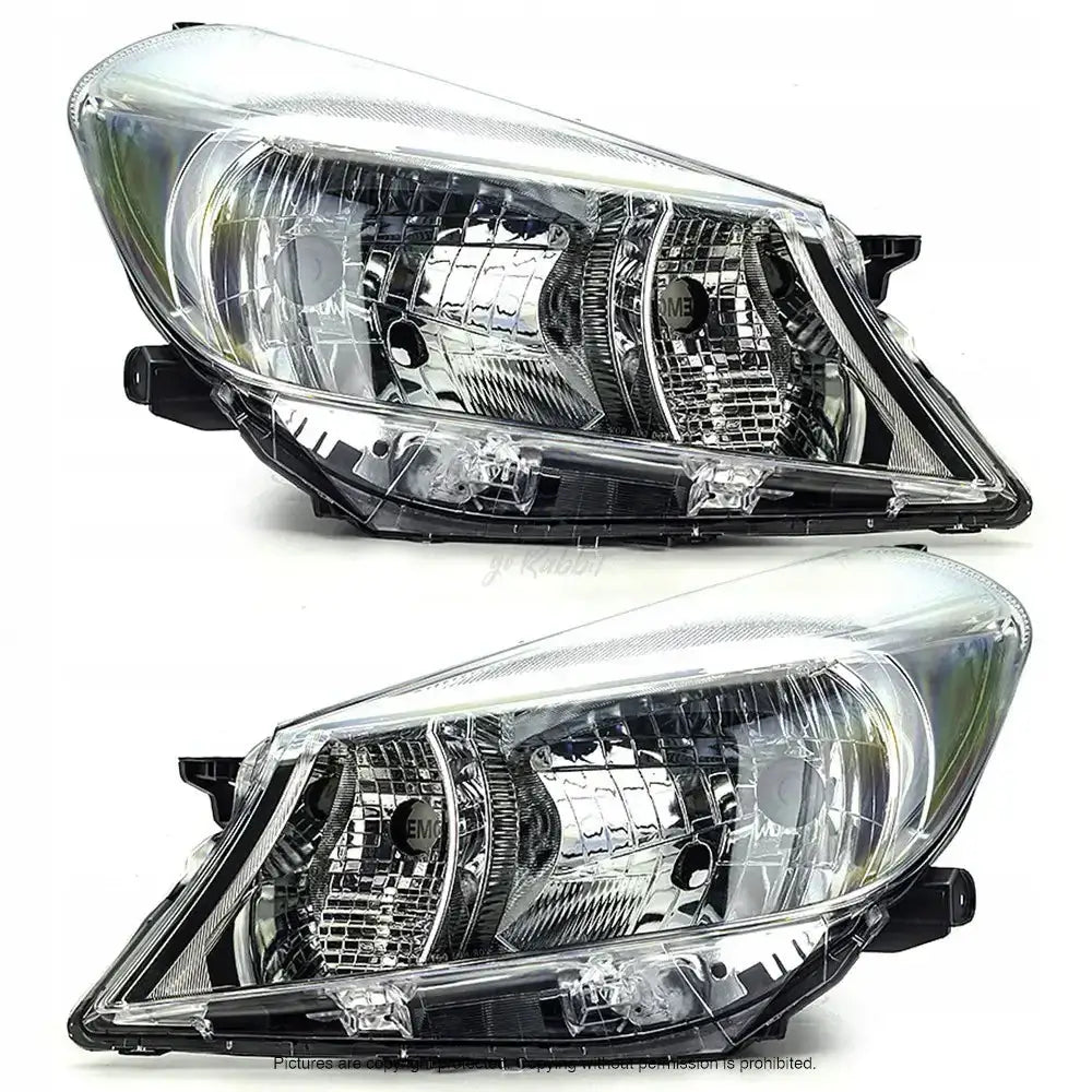 Frontlykter Toyota Yaris 10-14 sett fra skrå vinkel med klare linser og detaljerte innvendige lamper.