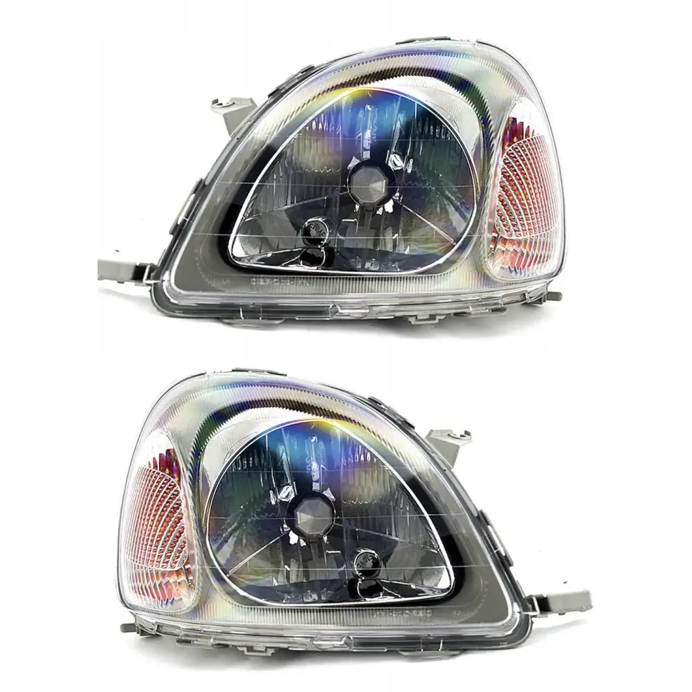 Frontlykter Toyota Yaris 99-03 H4 sett fra skrå vinkel med oransje sidefelt mot hvit bakgrunn.