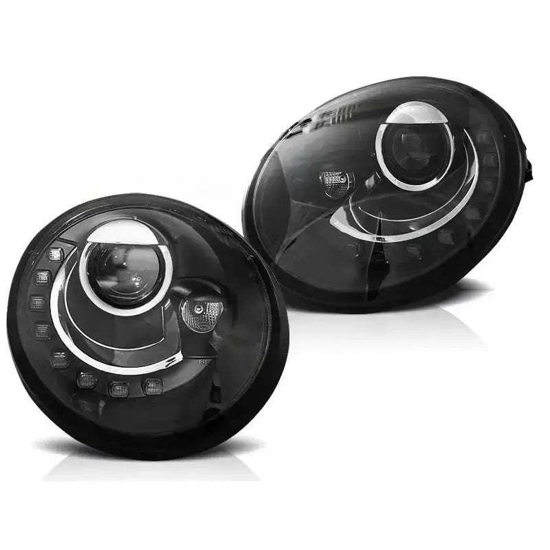 Hovedlykter Vw Beetle 10.98-05.05 i svart med LED-striper og kromdetaljer, sett fra skrå vinkel.