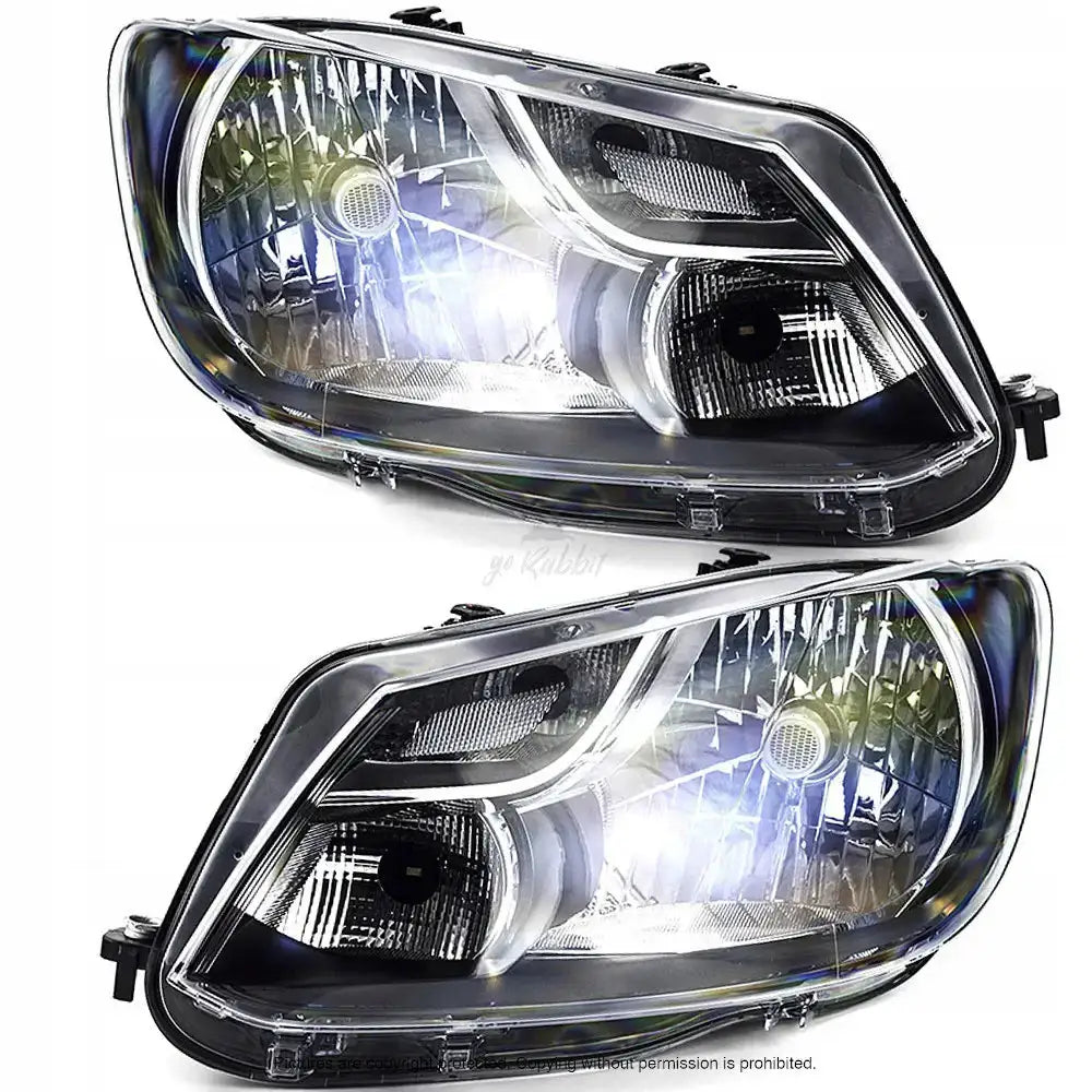 Frontlykter Vw Caddy 04-10 H4 i klar plast med svart innfatning, sett fra skrå vinkel.