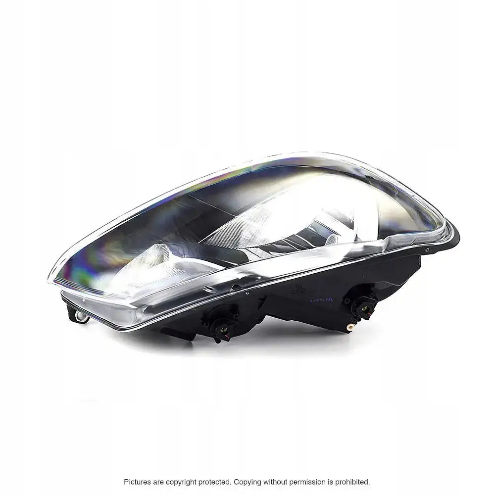 Frontlykter Vw Caddy 04-10 H4 i klart plast og svart materiale vist fra skrå sidevinkel.