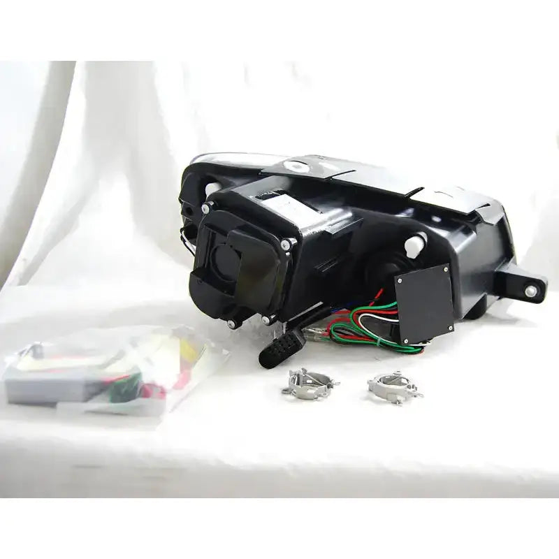 Hovedlys Vw Passat B6 3C med ledninger, metallfester og smådeler på hvit bakgrunn.