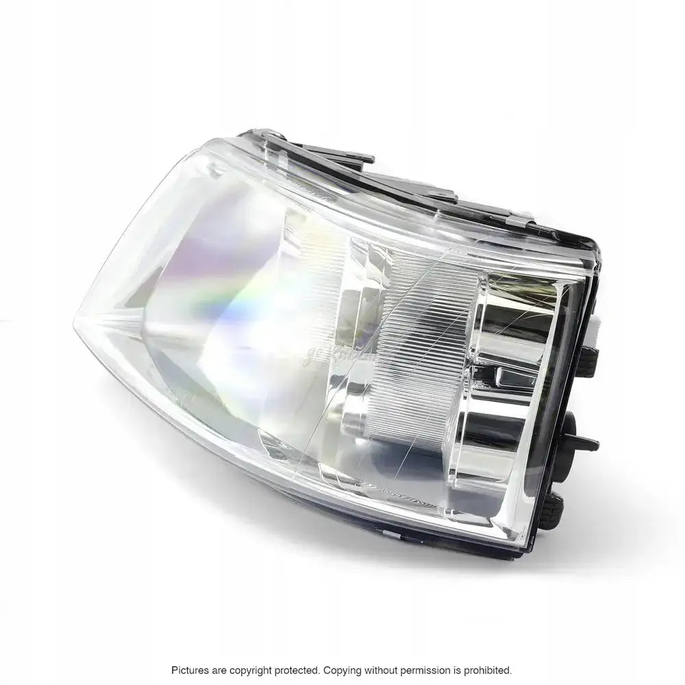 Frontlykter Vw T5 03-09 med klar plast, kromdetaljer og sorte festeklips, sett fra skrå vinkel.