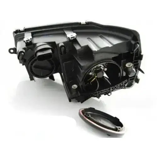 Hovedlykter Vw T5 2010-15 Tru DRL Xenon Look Black bakfra med åpninger, ledninger og løst deksel.