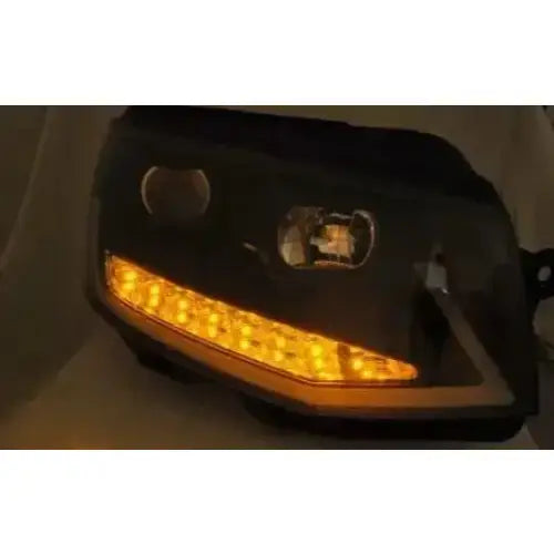 Hovedlys Vw T6 Black-Chrome Tube Light med tent gul-oransje LED-stripelys i mørkt miljø.