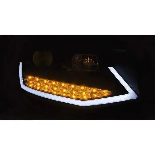 Headlamp Vw T6 15- svart LED frontlykt med oransje pærer og hvit ramme lyser i mørket.