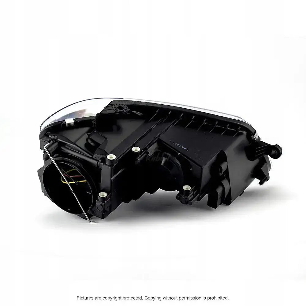 Headlamp Vw Touran 07-10 sett bakfra med synlige festeskruer, ledninger og bakdeksel mot hvit bakgrunn.