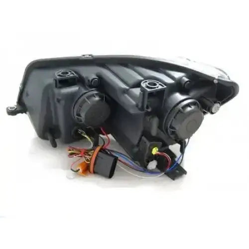 Headlamp bakside av Vw Touran II frontlykt i svart plast med ledninger og runde deksler.