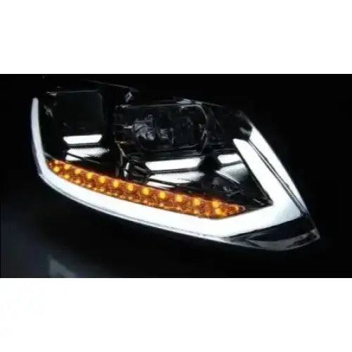 Headlights Vw Touran II nærbilde av sort billykt med oransje LED-lys og kromdetaljer på mørk bakgrunn.