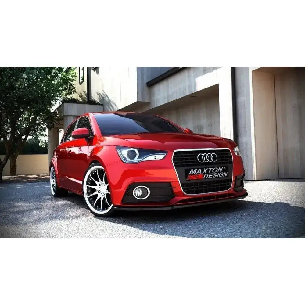 Frontleppe på Audi A1 Preface med sorte og kromfelger foran moderne bygning.