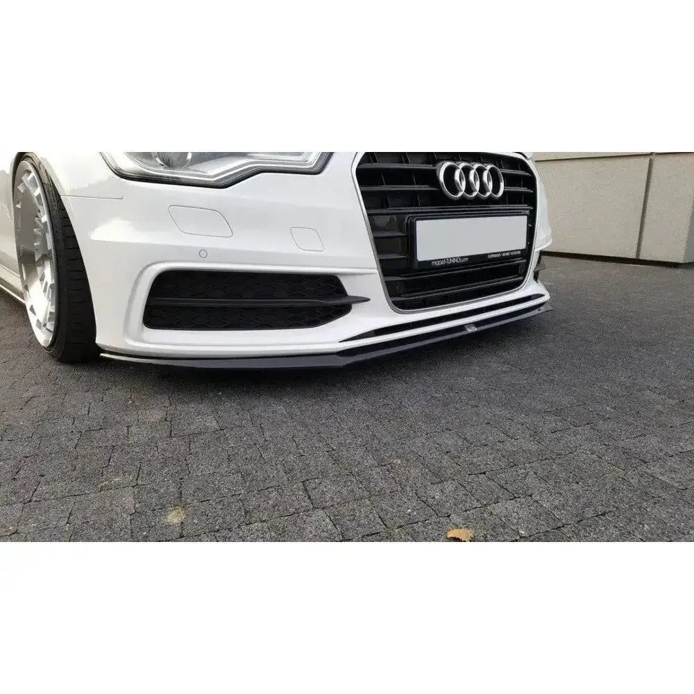 Frontspoiler Audi A6 C7 S-Line V.2 i sort på hvit bil, nærbilde fra skrå vinkel på bakkenivå.