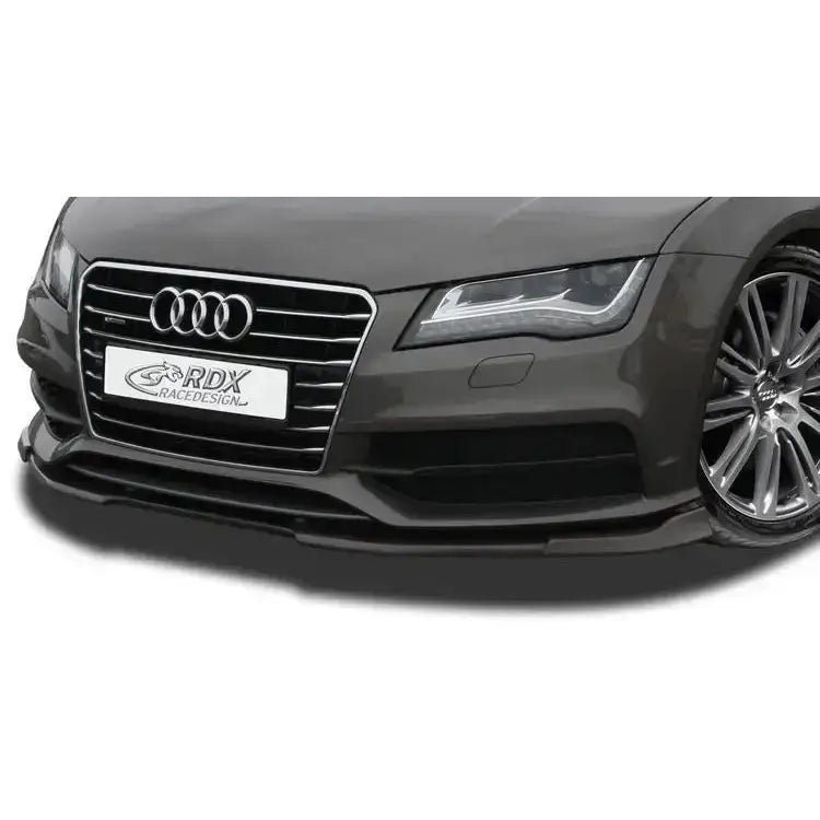 Frontspoiler Audi A7/S7 10-14 i sort plast montert på bil, sett skrått forfra med grill og høyre frontlys.
