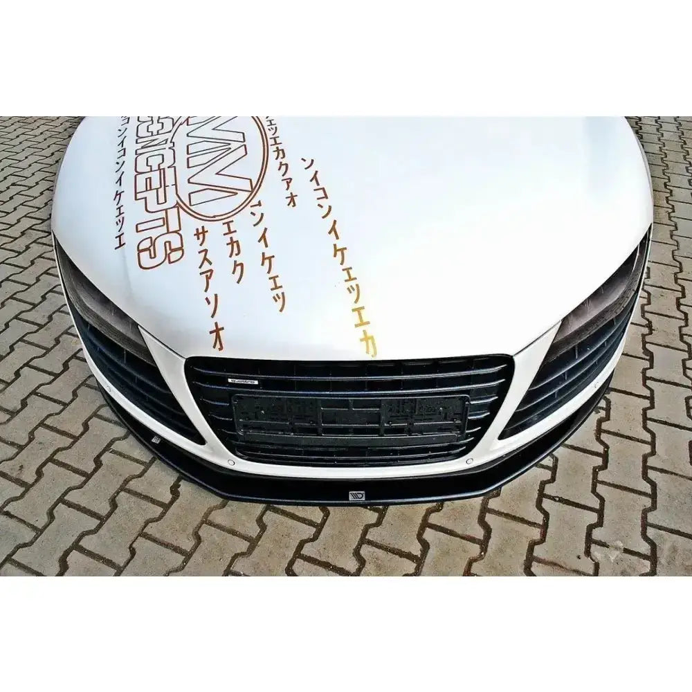Frontleppe Audi R8 2006-2015 montert på hvit bil med svart grill og gull klistremerker på panseret.