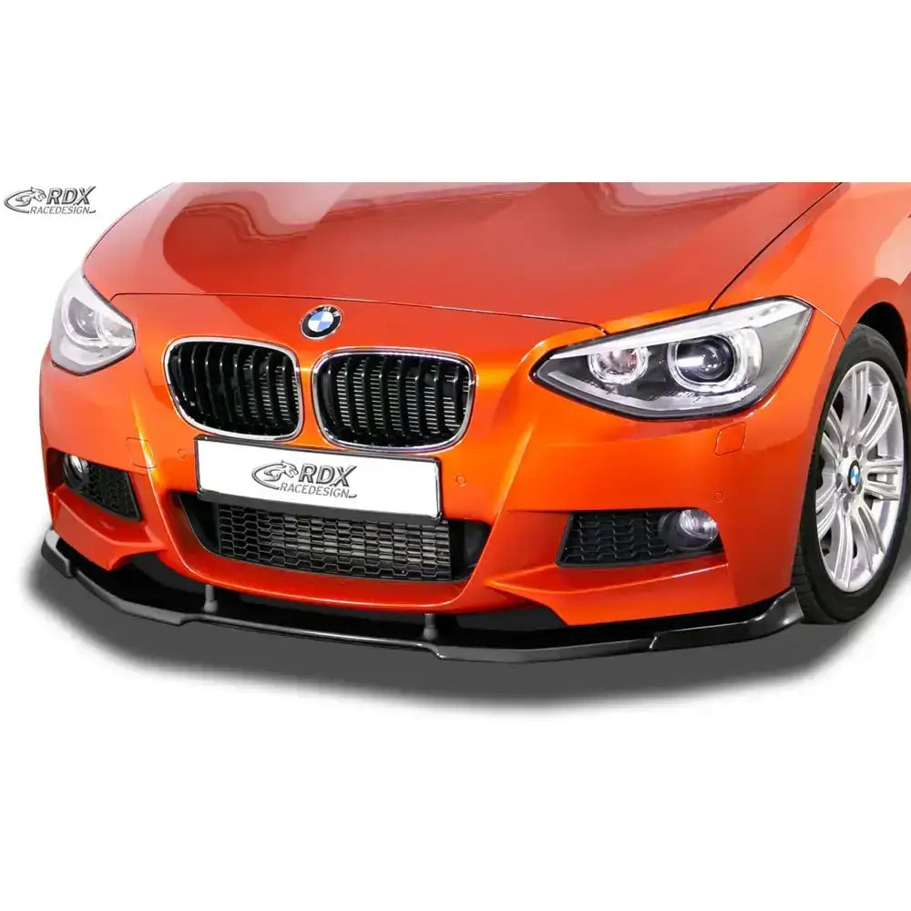 Spoiler til BMW 1 F20/F21 11-15 M-Tech, montert under fronten på oransje bil med sorte detaljer.