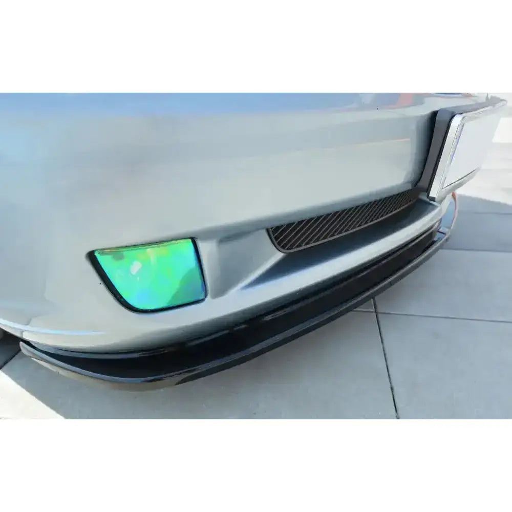 Front splitter Chrysler Crossfire i grått nærbilde med grønnaktig tåkelykt og svart leppe under.