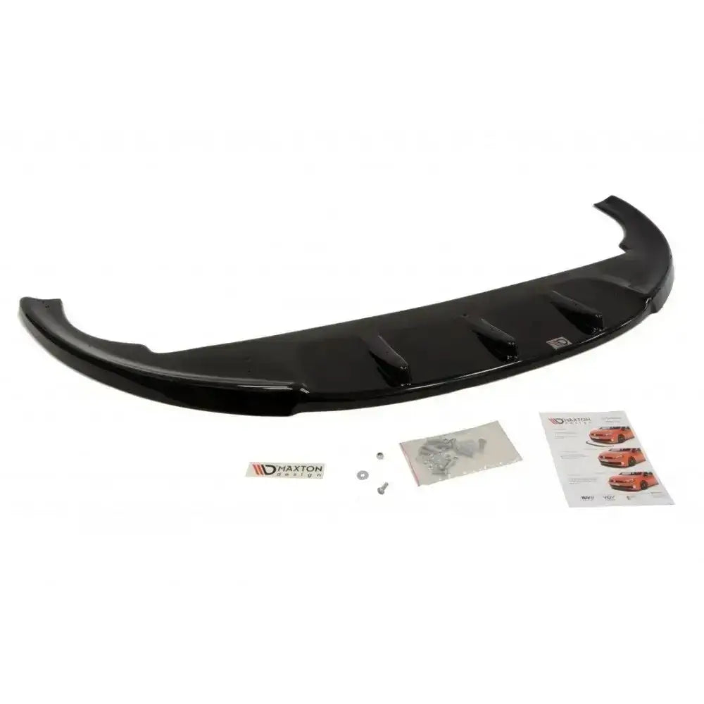 Front splitter til Fiat Bravo II i sort plast med monteringsutstyr og logoetikett mot hvit bakgrunn.