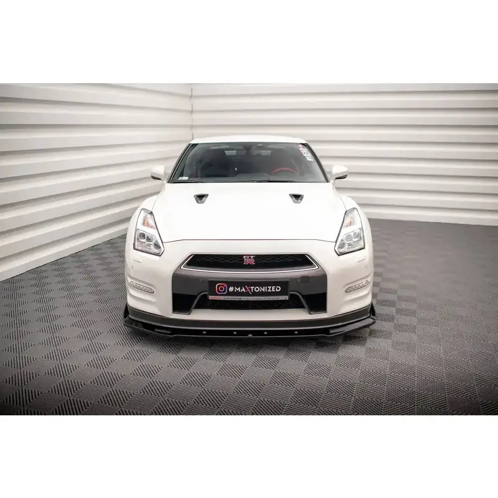 Frontleppe på Nissan GTR R35 Facelift 11-16 med svarte flaps, sett forfra i lyst rom.