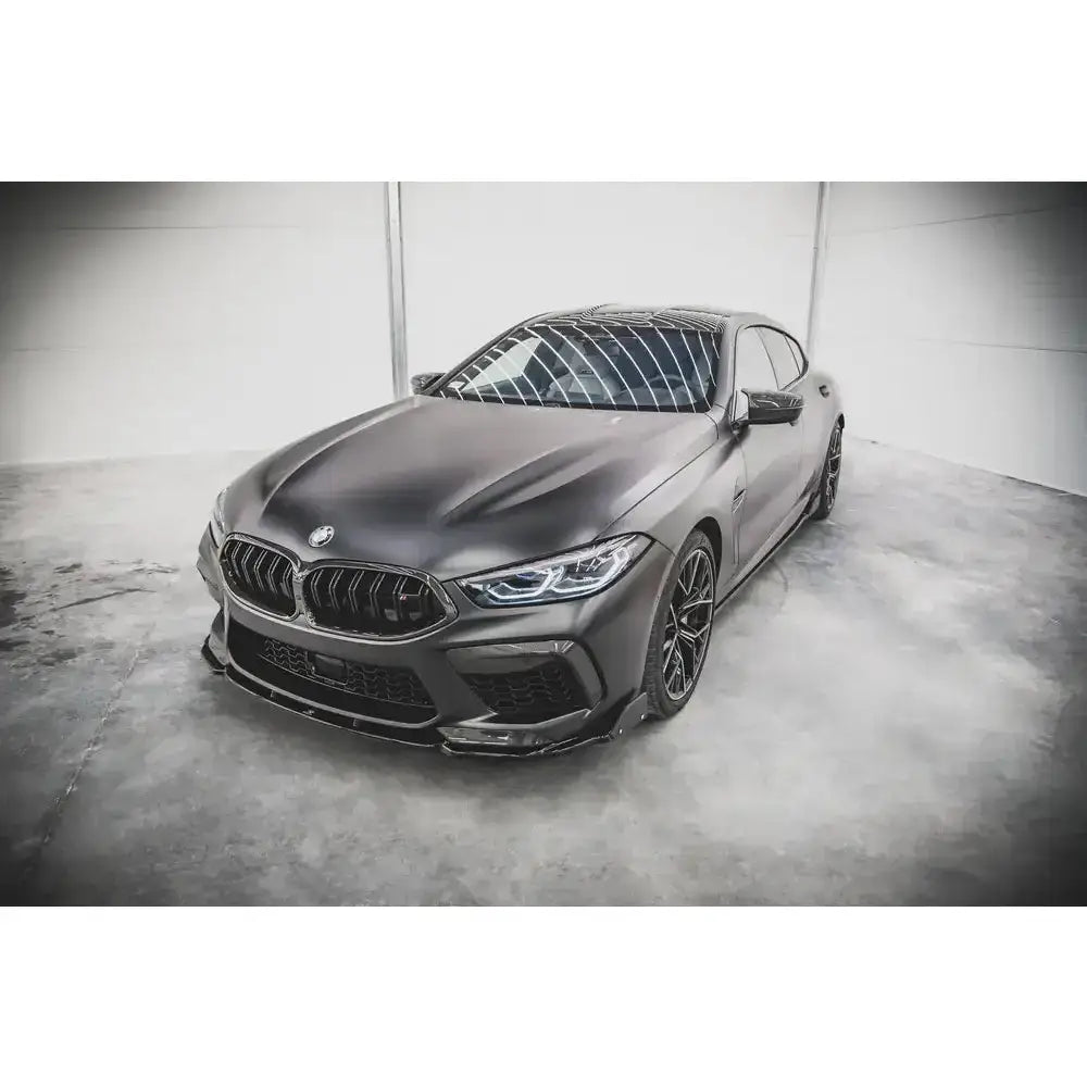 Spoiler på BMW M8 Gran Coupe F93 med flaps, matt mørk grå finish, sett fra skrå front i industrilokale.