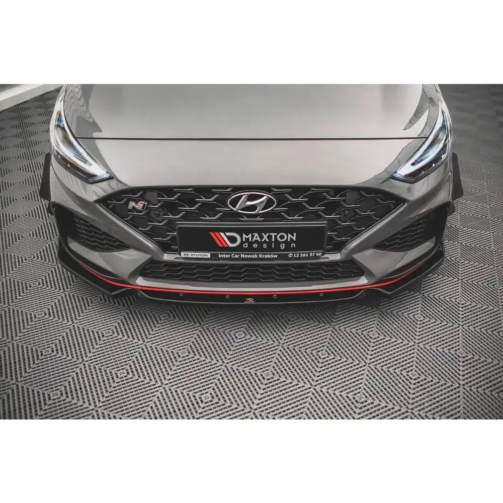 Frontspoiler på grå Hyundai I30 N Mk3 Facelift med røde detaljer og Maxton Design-logo på skiltet.