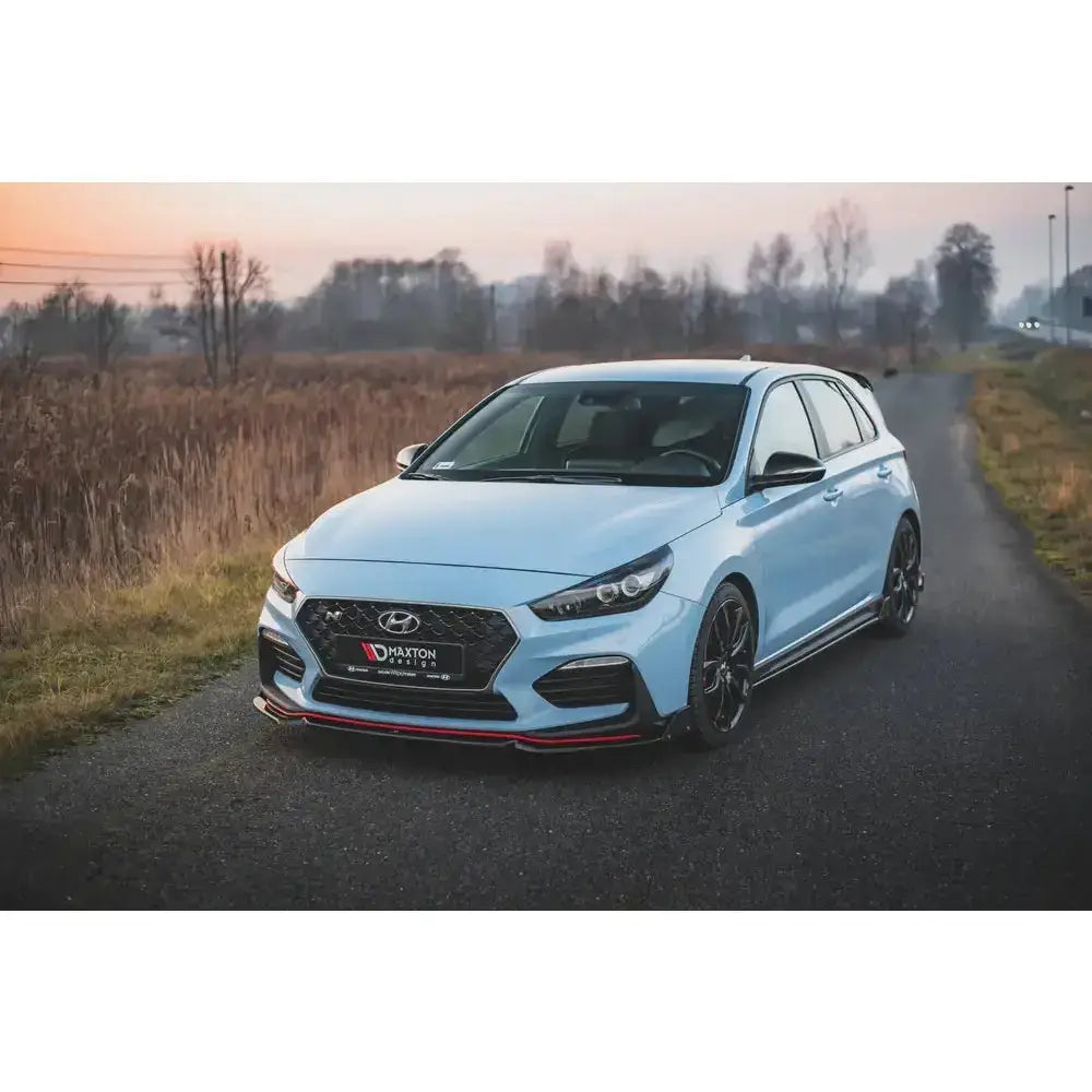 Frontleppe på Hyundai I30 N Mk3 med flaps V.6, montert på lyseblå bil parkert ved solnedgang.