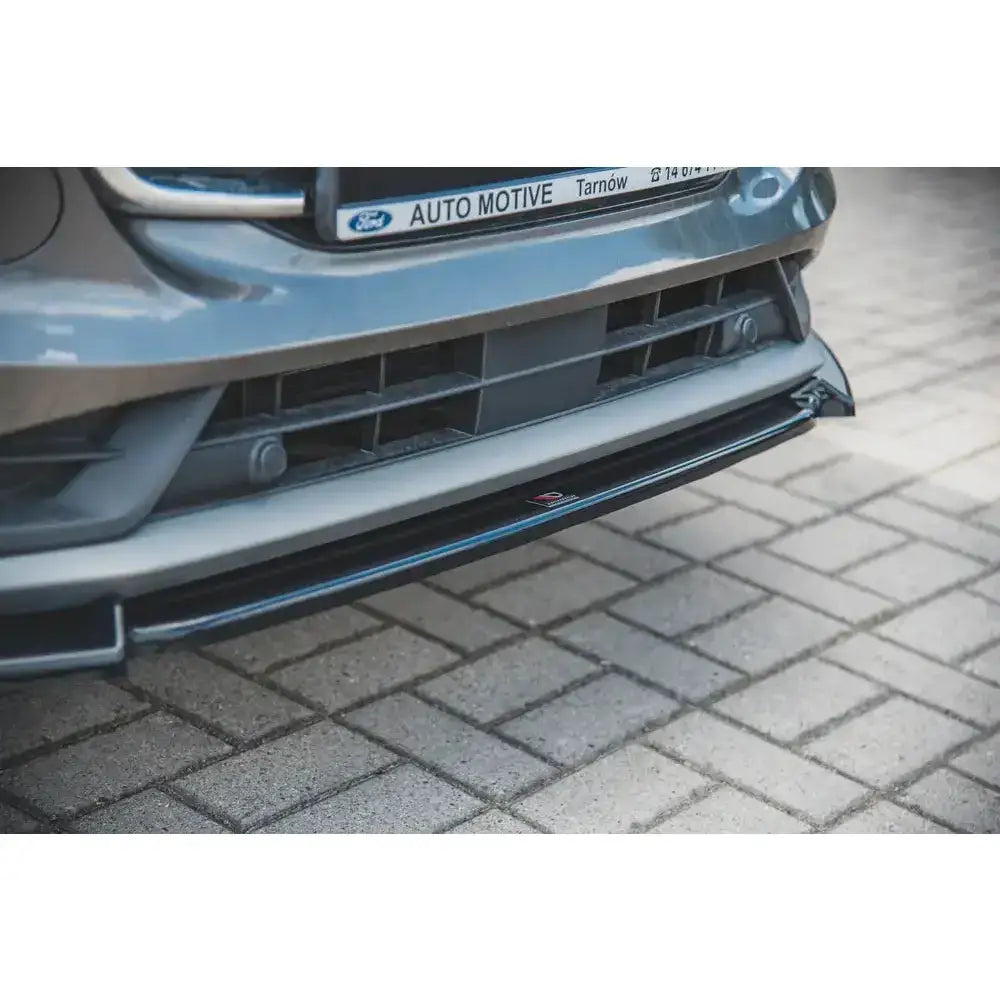Front splitter på sort plastspoiler montert under støtfanger på grå Ford Puma, nærbilde forfra.