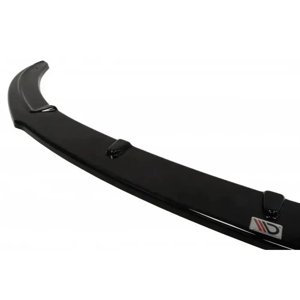 Spoiler til Hyundai Veloster i sort, glanset plast med logo på enden, fotografert fra skrå vinkel.