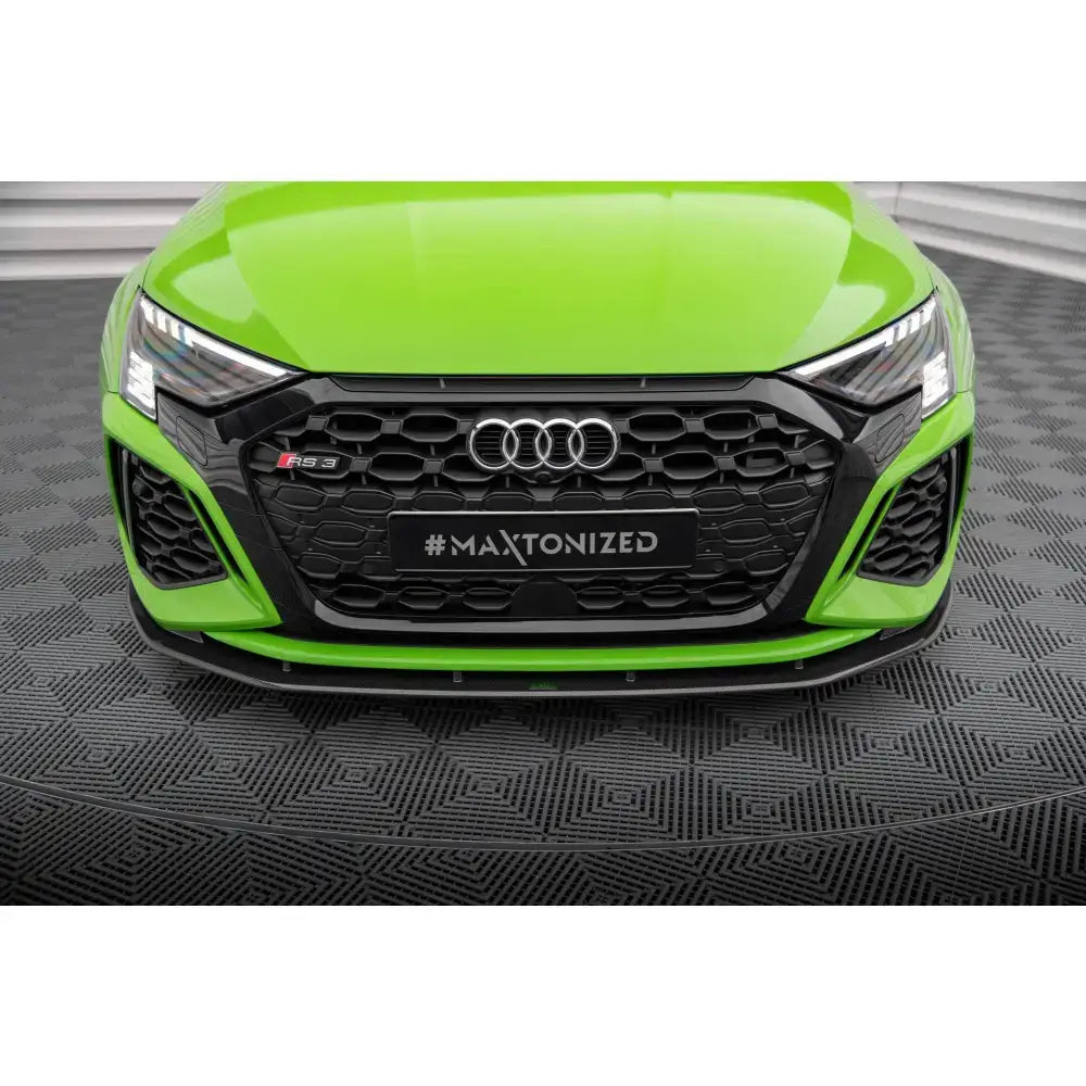 Front splitter på Audi RS3 8Y med karbon, svart grill og markante LED-frontlykter sett forfra.