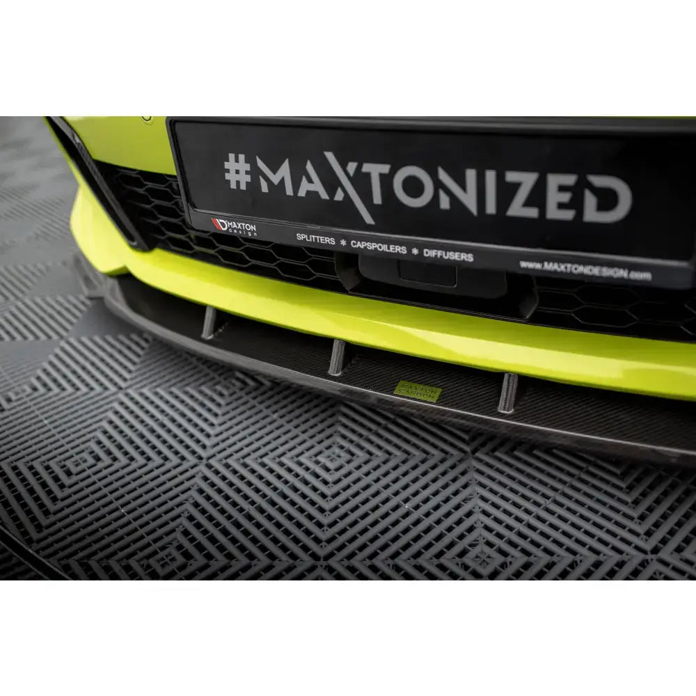 Spoiler BMW 1 F40 M-Pack karbon nærbilde med sort frontsplitter og bilens logo sett skrått ovenfra.