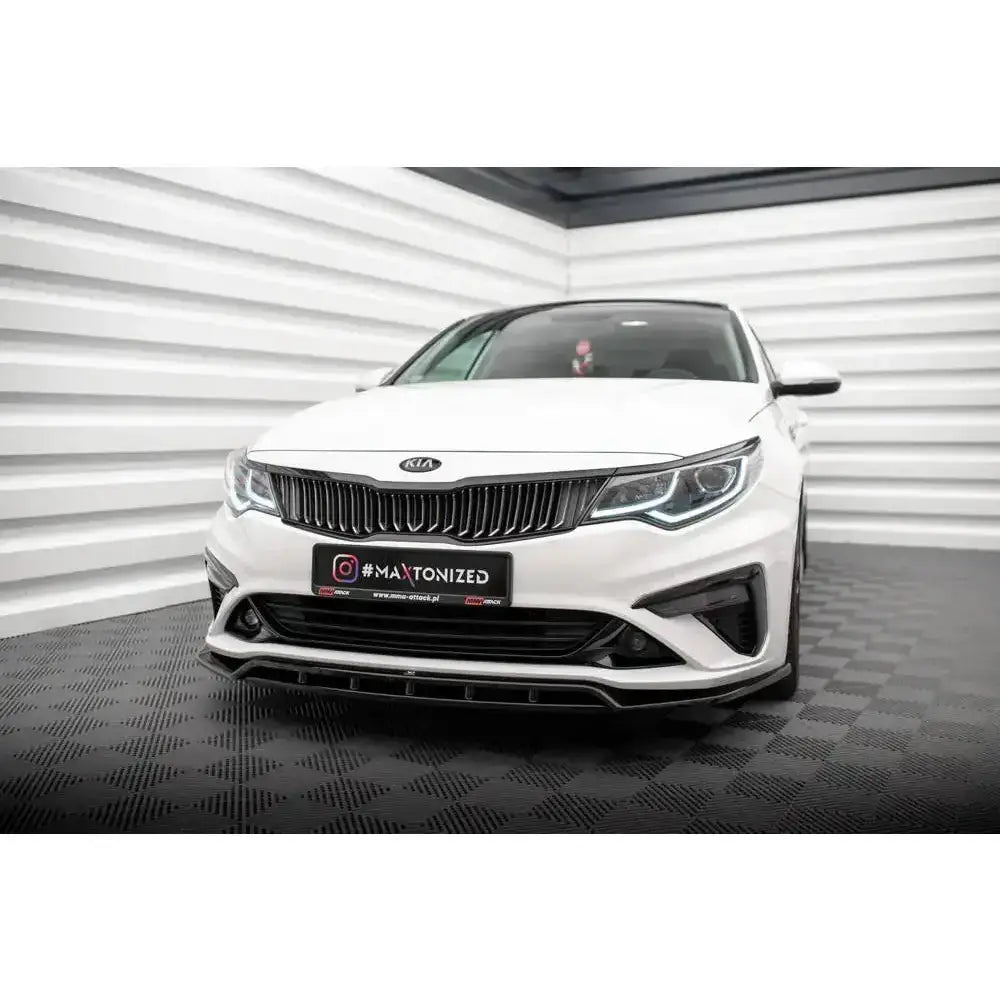 Front splitter på Kia Optima 18-20 Mk4 Facelift, hvit bil med sort frontspoiler i lyst rom.