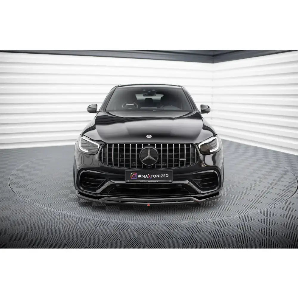 Front splitter på Mercedes GLC 63 SUV med sort lakk og markant grill, fotografert forfra i showroom.
