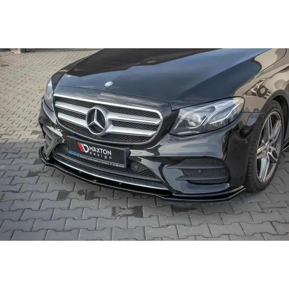 Frontleppe til Mercedes E43 AMG W213, sort bil med blank spoiler og kromdetaljer sett i halvprofil.